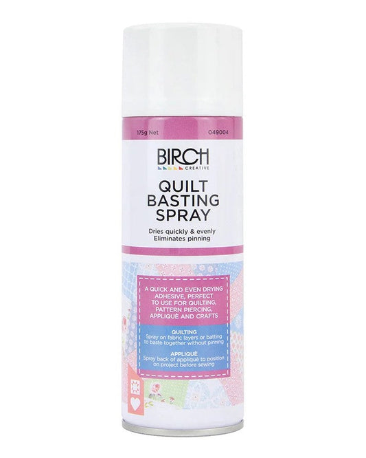 A can of Birch Quilt Basting Spray on a plain white background. The can is white with pink bands and black text, featuring a small multicolor patterned section near the bottom.