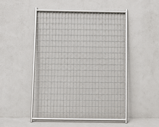 A square metal mesh fence panel with a silver aluminum frame, standing upright against a textured gray concrete wall.