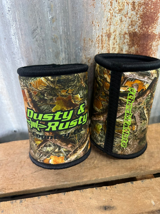 Two camouflage-patterned can coolers with 'Dusty & Rusty' branding on a wooden surface.