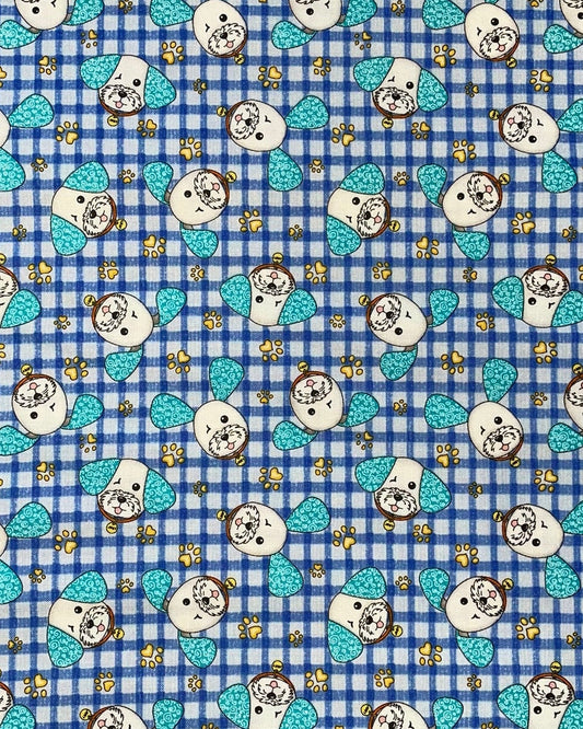 A close-up of a fabric pattern featuring a blue and white gingham check background with repeating cartoon dog faces, turquoise bows, and small yellow stars.