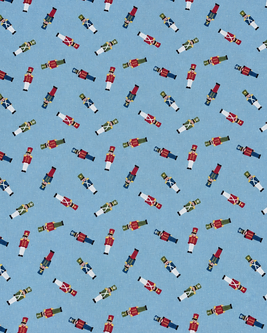 A repeating pattern of small nutcracker figures in red, white, blue, green, and gold on a light blue background.